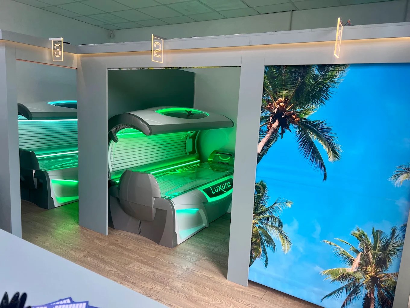 Luxura Hybrid laydown sunbed glowing green in the salon